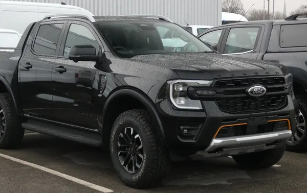 A black Ford Ranger Wildtrak X double cab ute parked on wet asphalt.