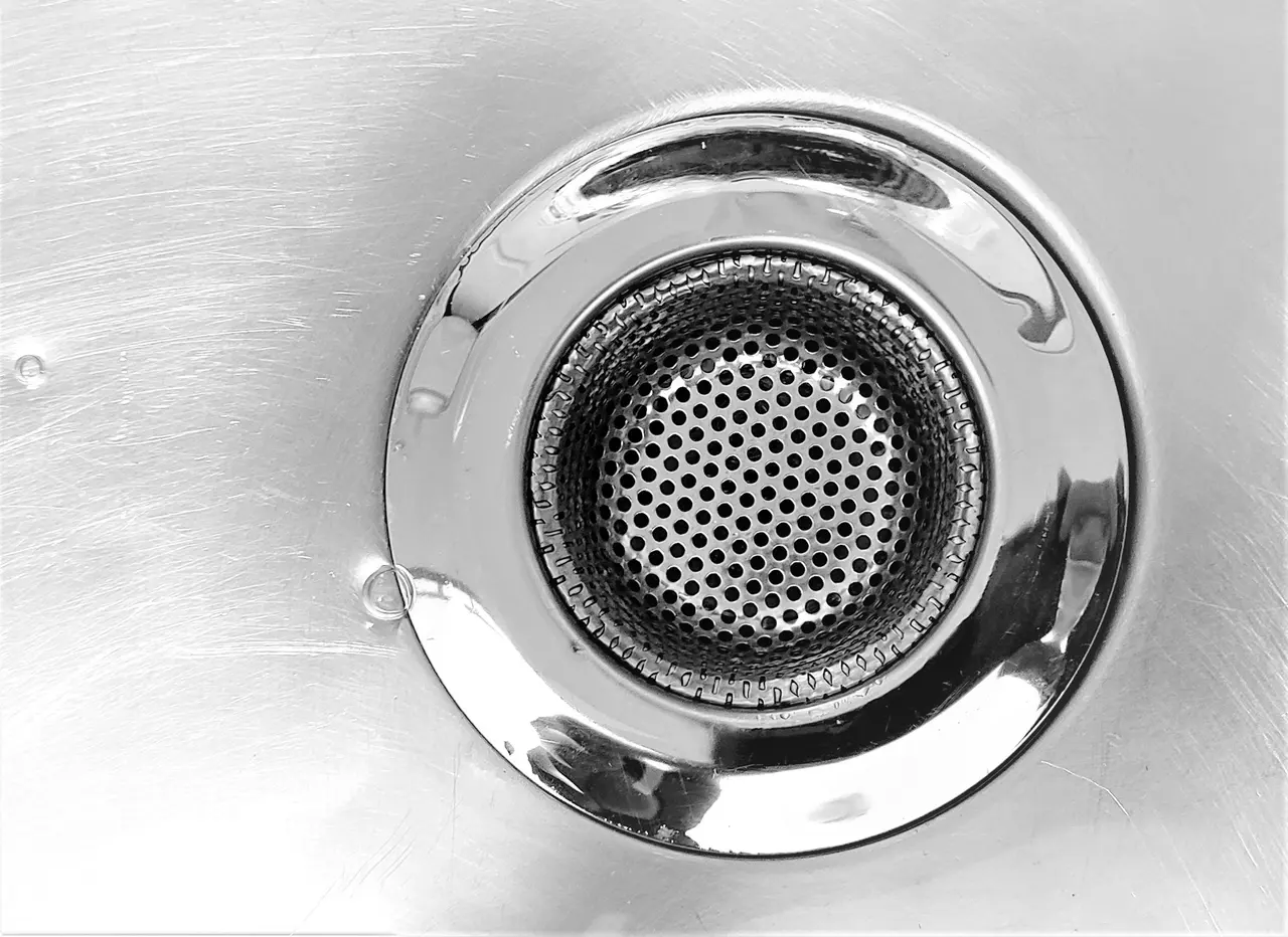 A stainless steel sink drain, close up